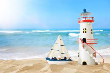 vintage wooden boat and lighthouse over beach sand and sea landscape background