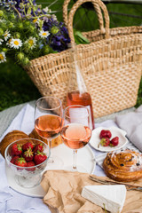 Wall Mural - Beautiful summer picnic with strawberries, cheese and rose wine on the lawn in the city park