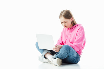 Wall Mural - upset teenage girl with crossed legs using laptop isolated on white, illustrative editorial