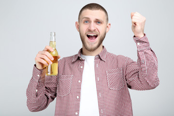 Poster - Young man with bottle of beer on grey background