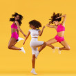 © Mike Orlov - Three strong and happy athletic women, jumping or dancing on yellow background wearing color sportswear. Fitness and sport motivation.