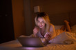 © lashkhidzetim - Bedroom evening - woman with laptop lying down in bed.