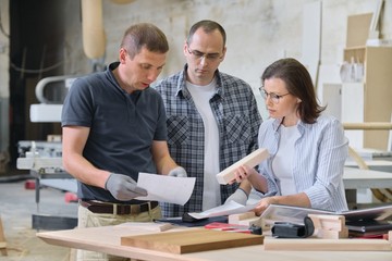 Wall Mural - Team of woodworking workshop workers are discussing. Group of people client, designer or engineer and workers discuss work