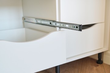 Furniture details close-up, installation of drawers in the cabinet