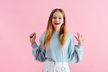 Wall Mural - happy pretty teenage girl looking at camera isolated on pink