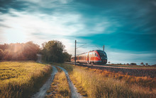 High-speed Train Moving Through Nature At Sunset