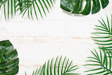 Palm leaves on white wooden background top view.