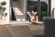 © Westend61 - Young woman sitting on terrace at home enjoying the sunshine