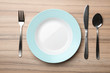 © New Africa - Stylish ceramic plate and cutlery on wooden background, flat lay
