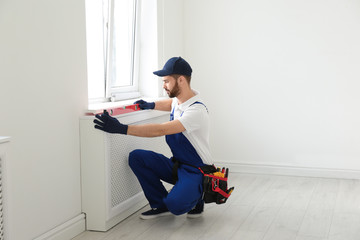 Sticker - Handyman working with building level indoors. Professional construction tools