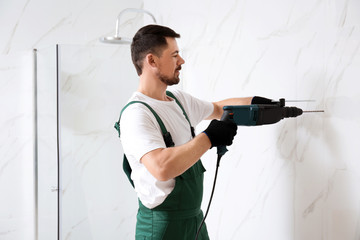 Canvas Print - Handyman working with drill in bathroom. Professional construction tools