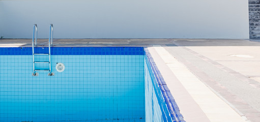 Empty dry swimming pool preparing for cleaning.