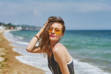 Portrait of a young woman wearing sunglasses on the sea coast