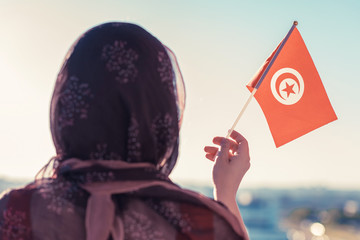 Wall Mural - Muslim woman in scarf with Tunisia flag of at sunset.Concept