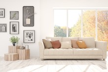 Stylish Room In White Color With Sofa And Autumn Landscape In Window. Scandinavian Interior Design. 3D Illustration