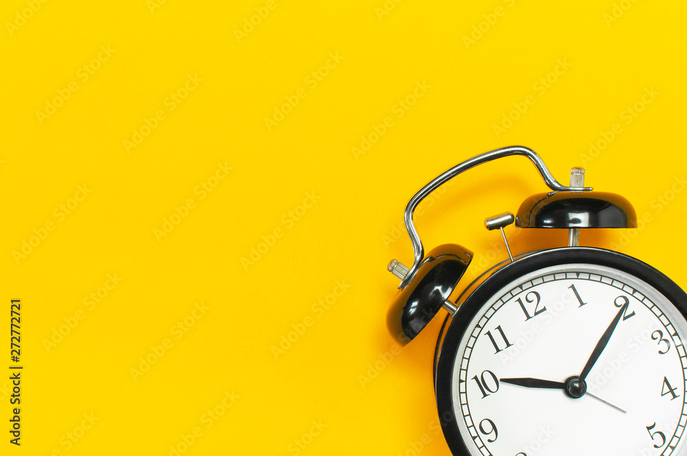 Black retro alarm clock on yellow background top view Flat lay copy space. Minimalistic background, concept of time, deadline, time to work, morning - obrazy, fototapety, plakaty 
