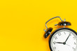 © olgaarkhipenko - Black retro alarm clock on yellow background top view Flat lay copy space. Minimalistic background, concept of time, deadline, time to work, morning