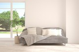 Fototapeta  - Stylish room in white color with sofa and summer landscape in window. Scandinavian interior design. 3D illustration