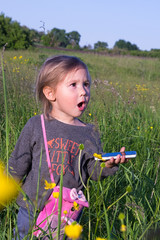  little girl with a mobile phone on a walk, emotions