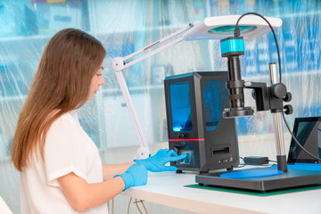 Canvas Print - Woman worker in control of Resin LCD / DLP / SLA 3D Printer in technology lab