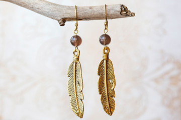 Wall Mural - Mineral stone shade quartz and pearl beads feather shape earrings on neutral background