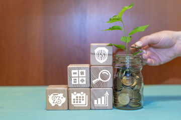 Hand puts coin in jar and wooden blocks pyramid with rise dividends icons set. Dividend concept.