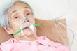 Closeup of female senior patient putting inhalation or oxygen mask in hospital bed or home,sick elderly asian woman undergoing treatment with best medicine,healthcare concept