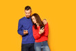 © Pixel-Shot - Young couple with mobile phones on color background