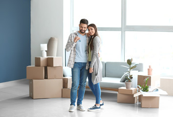 Young couple with keys in their new house