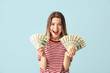 © Pixel-Shot - Happy young woman with money on color background