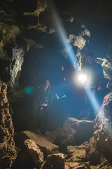 Family exploring huge cave. Adventure travellers dressed cowboy hat and backpack, group of people. vertical photo vacation, tourist route. ancient crystal formations, geology, village Kryvche. Ukraine