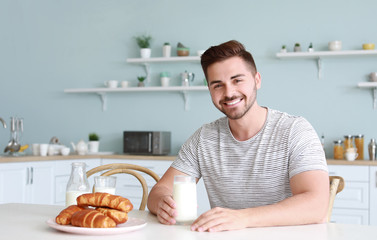 Sticker - Handsome man drinking tasty milk in kitchen at home