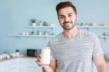 Sticker - Handsome man drinking tasty milk in kitchen at home