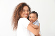 © Pixel-Shot - Happy African-American mother with cute little baby on white background