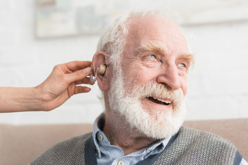 Wall Mural - Happy grey haired man with hearing aid, and looking away