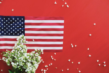 Wall Mural - American flag from United States on red background with flowers and copy space.  Fourth of July or Memorial day holiday banner.
