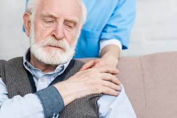 Wall Mural - Nurse putting hand on sad senior man