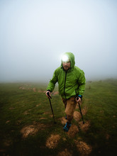 Young Man With Headlamp Hiking Through The Fog