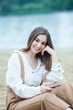 © Nomad Pixel - Girl outdoors texting on her mobile phone. Girl with phone. Portrait of a happy woman text sms message on her phone.