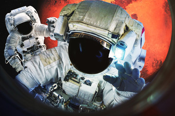 Wall Mural - astronauts near the mars planet view from the illuminator of spaceship. science fiction. elements of