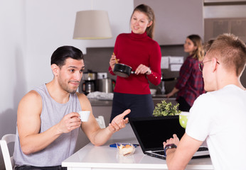 Wall Mural - Man helping guy to plan tourist itinerary at hostel kitchen