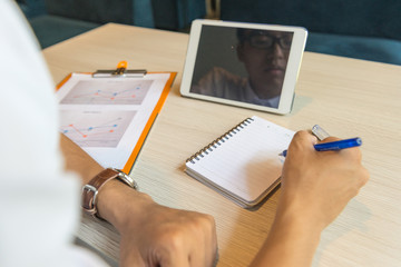 Rear view of man writing notes in the office