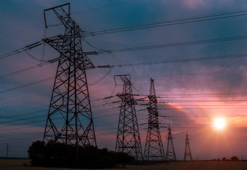  high-voltage power lines at sunset. greeb field.