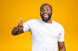 © denis_vermenko - Portrait of happy afroamerican handsome bearded man laughing and showing thumb up gesture isolated against yellow background.