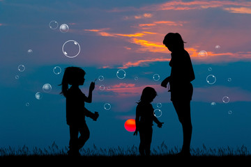 Wall Mural - girl playing with soap bubbles at sunset