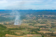Aerial view of small area fire In the agricultural area With mountains on the horizon On a sunny day blue sky