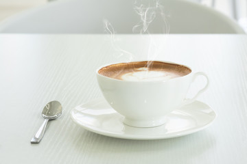 Wall Mural - Cappuccino in a white cup on a white table