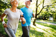 Mature Couple Jogging And Running Outdoors In City