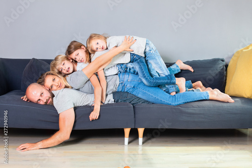 The Family Of Five Lie On Top Of Each Other While Lying Across The