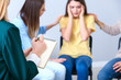 © Pixel-Shot - People calming woman at group therapy session